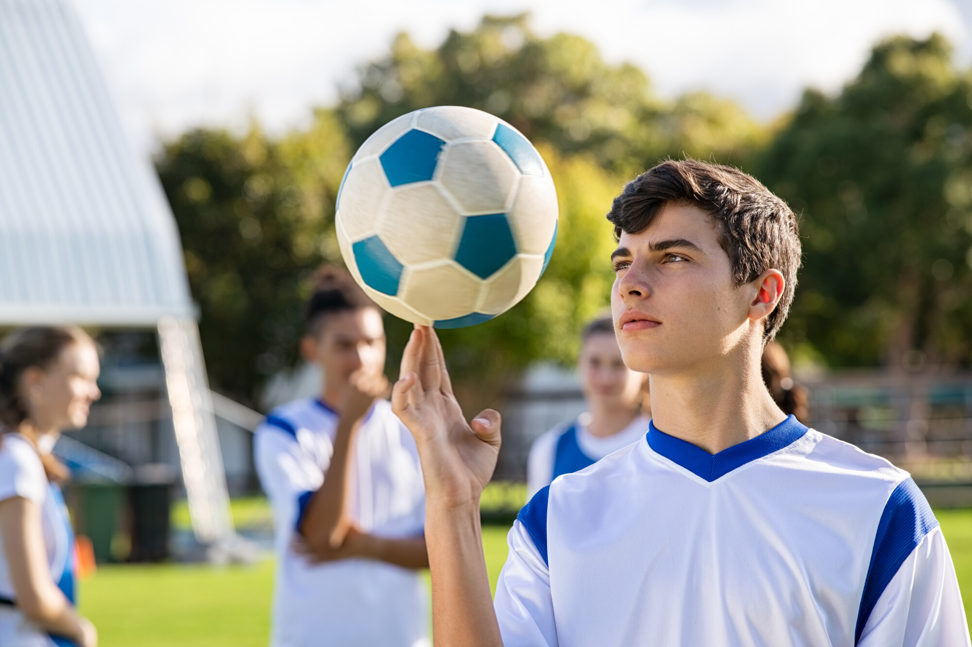 Football,Guy,In,Uniform,Spinning,Football,On,Finger.,Handsome,Soccer
